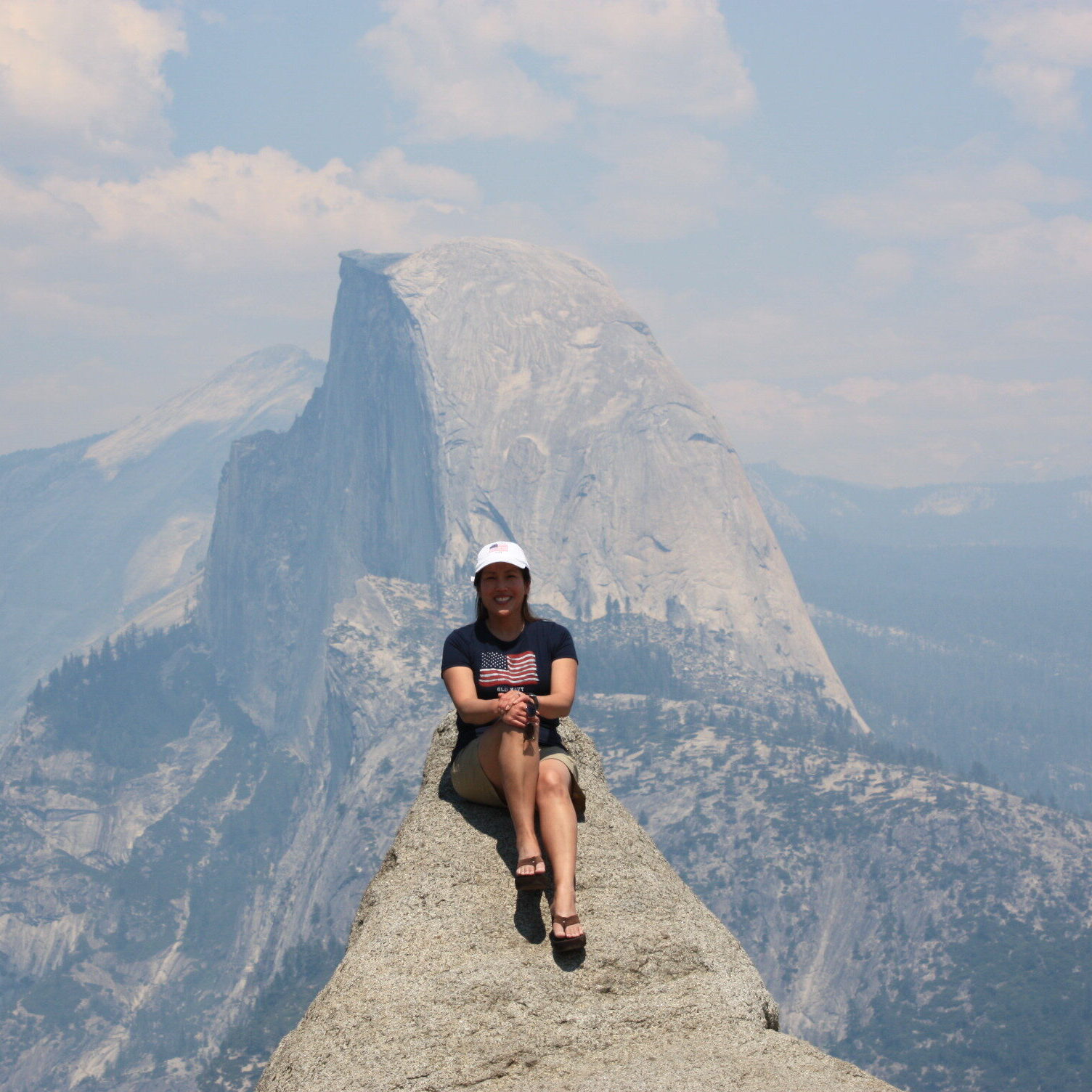 Joan F Barrera sitting on a rock in front of a mountain