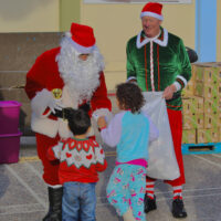 241230 Press Release - 42nd Annual CARES Holiday Gift Program Santa handing presents to children