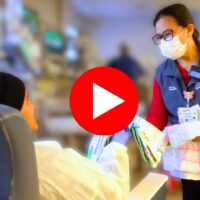 Image of staff handing a patient a quilt