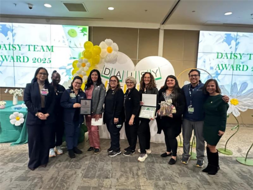 The Nursing Education Team standing in front of a balloon arch with balloon daisies